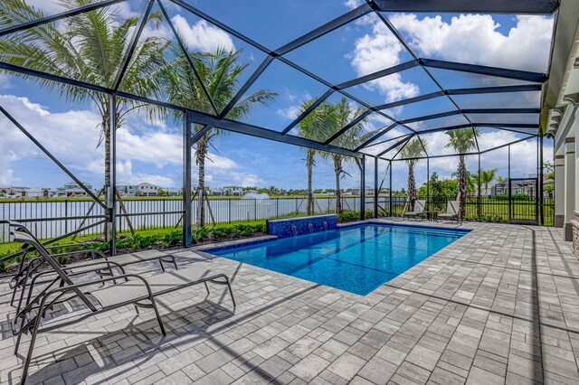 view of pool featuring pool water feature, a water view, glass enclosure, and a patio area