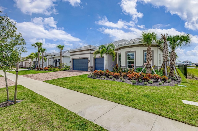 mediterranean / spanish home featuring a garage and a front yard