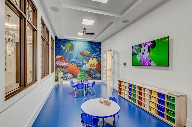 recreation room with an inviting chandelier and a tray ceiling