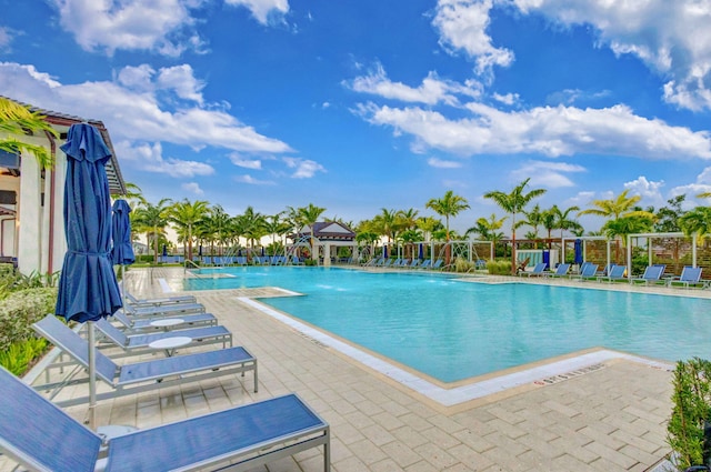 view of swimming pool with pool water feature and a patio area