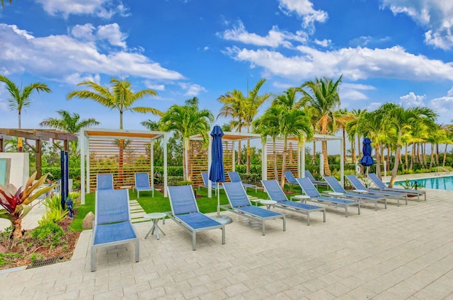 view of jungle gym with a community pool, a pergola, and a patio area