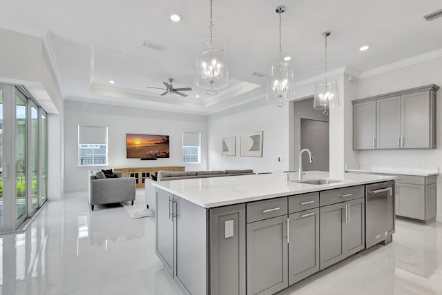 kitchen featuring gray cabinets, an island with sink, sink, and pendant lighting