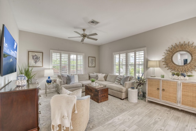 living room featuring a healthy amount of sunlight, ceiling fan, and light hardwood / wood-style floors