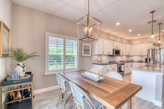 dining area featuring a notable chandelier and sink