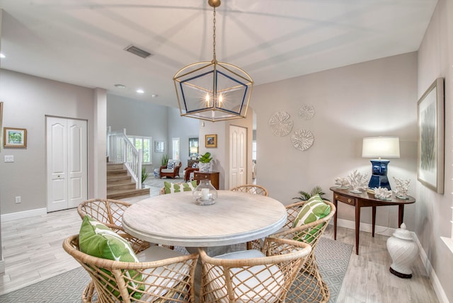 dining area with a notable chandelier and light hardwood / wood-style floors