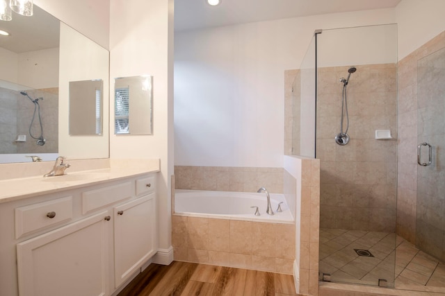 bathroom featuring hardwood / wood-style floors, vanity, and independent shower and bath