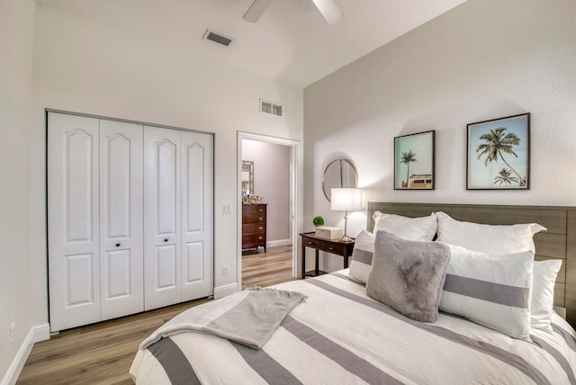 bedroom with ceiling fan, a closet, and light hardwood / wood-style flooring