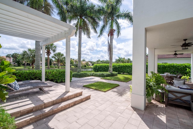 view of patio with a pergola, a water view, and ceiling fan