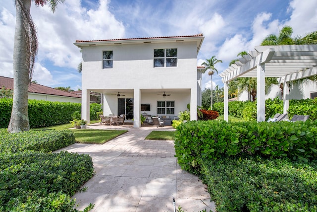 rear view of property with a pergola, a patio area, and ceiling fan