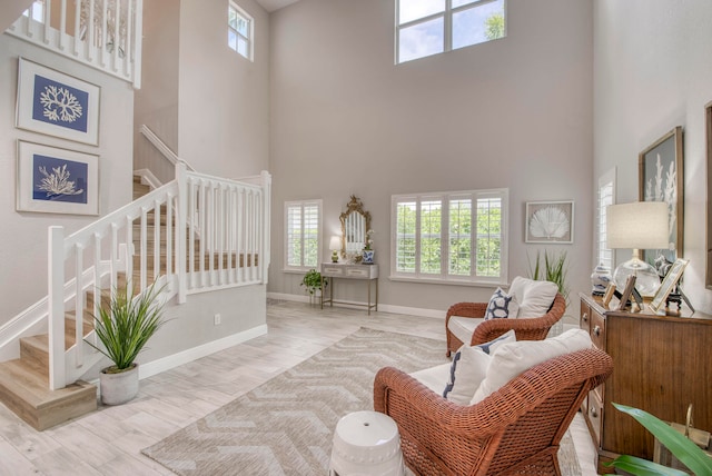 living room featuring a high ceiling and light hardwood / wood-style flooring