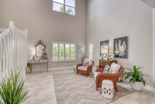 living area with a high ceiling and light hardwood / wood-style floors