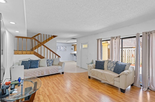 living room with light wood-type flooring and a textured ceiling