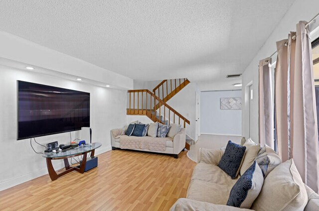 living room featuring a textured ceiling and light hardwood / wood-style flooring