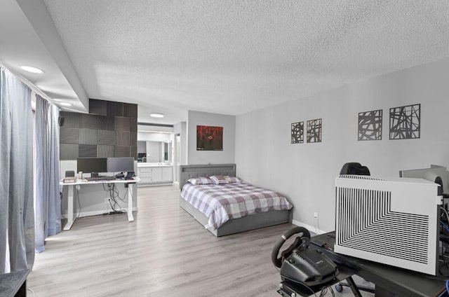 bedroom with light wood-type flooring and a textured ceiling