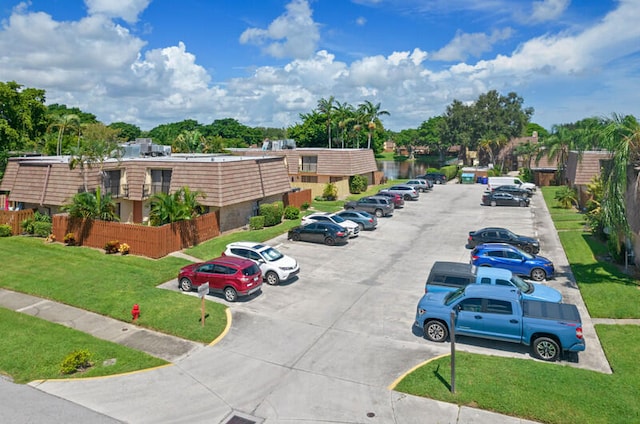 view of parking / parking lot featuring a lawn