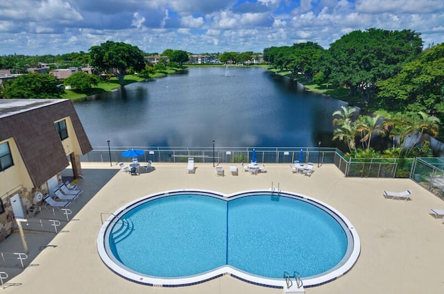 view of swimming pool with a patio area and a water view