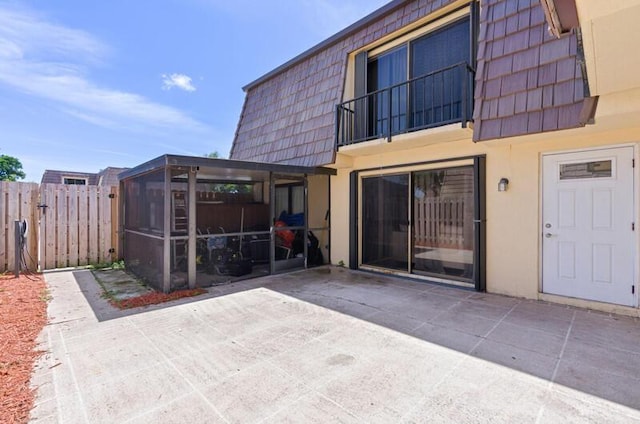 632 Springdale Cir, Palm Springs, FL 33461 - back of property with mansard roof, a sunroom, a patio, and stucco siding