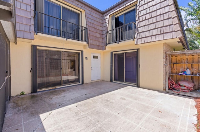 rear view of house with a patio area and a balcony