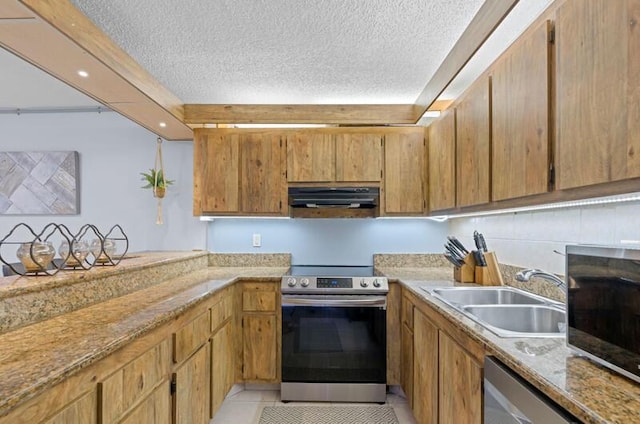 632 Springdale Cir, Palm Springs, FL 33461 - kitchen featuring appliances with stainless steel finishes, a sink, under cabinet range hood, a textured ceiling, and brown cabinets