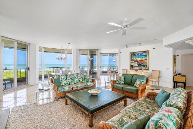 living area with tile patterned flooring, floor to ceiling windows, rail lighting, and a water view