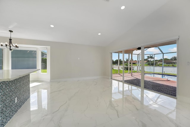 spare room featuring lofted ceiling, a water view, and a notable chandelier