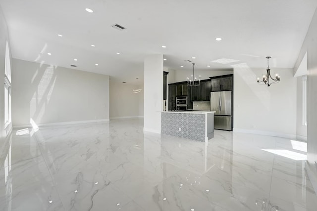 unfurnished living room with an inviting chandelier