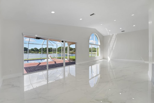 empty room featuring a water view and vaulted ceiling