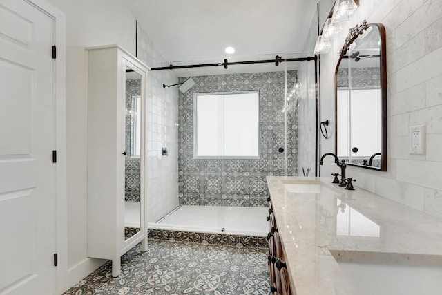 bathroom featuring a shower with door, vanity, tile walls, and tile patterned flooring