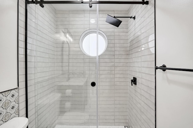 bathroom featuring walk in shower and toilet