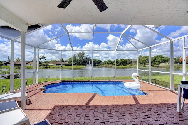 view of swimming pool featuring a lanai, a patio area, and a water view