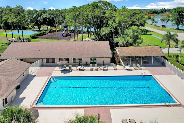 view of pool with a water view and a patio area