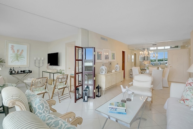 tiled living room with a notable chandelier