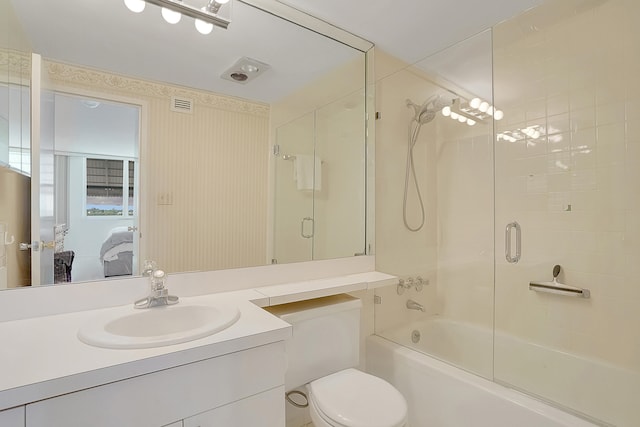 full bathroom with vanity, toilet, and bath / shower combo with glass door