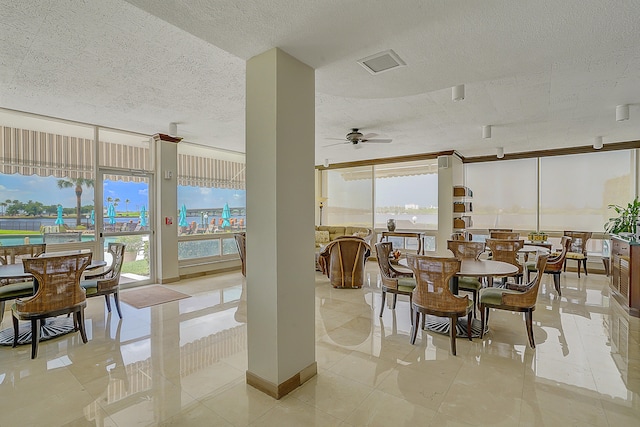 dining room with a textured ceiling, a healthy amount of sunlight, ceiling fan, and light tile patterned floors