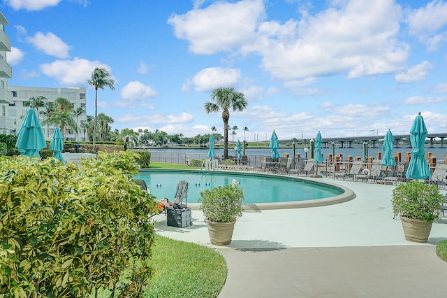 view of pool with a patio and a water view