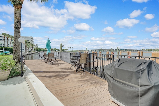 deck with a water view and area for grilling