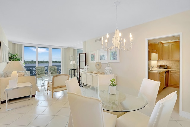 tiled dining area with floor to ceiling windows, an inviting chandelier, and sink