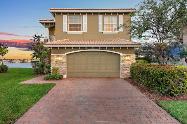 mediterranean / spanish-style home featuring a garage and a lawn