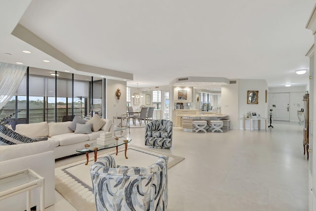 living room with expansive windows, plenty of natural light, and a notable chandelier