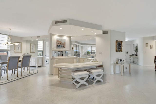 kitchen featuring kitchen peninsula, plenty of natural light, a chandelier, and decorative light fixtures