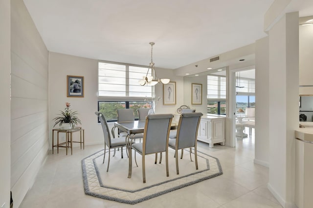 tiled dining room with an inviting chandelier