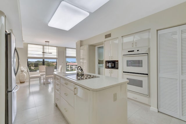 7567 Imperial Dr Unit 601, Boca Raton, FL 33433 - kitchen with electric cooktop, freestanding refrigerator, white double oven, black microwave, and a center island