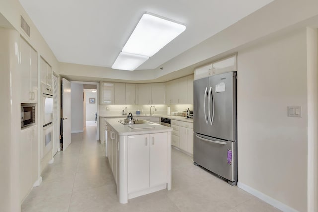 kitchen featuring white cabinetry, light tile patterned floors, a kitchen island with sink, and appliances with stainless steel finishes