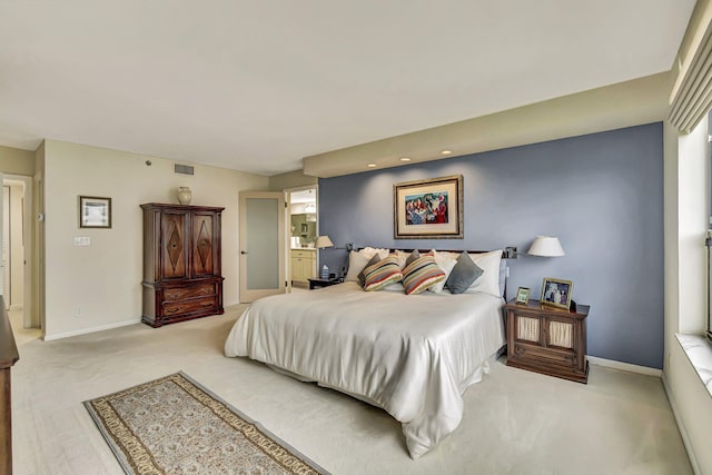 bedroom with light carpet and ensuite bathroom