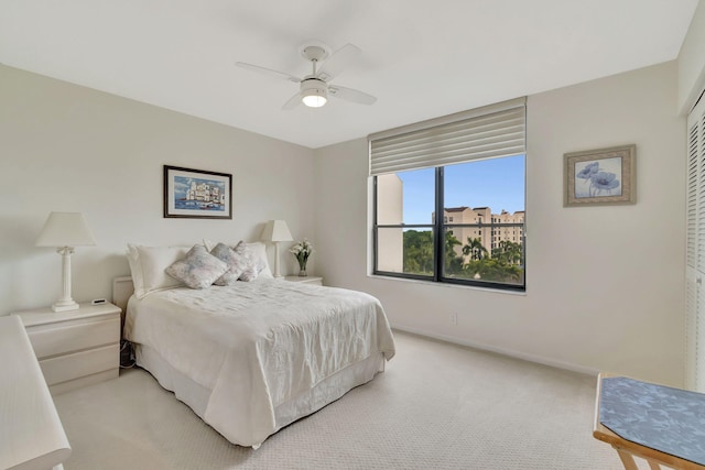 bedroom featuring ceiling fan, light carpet, and a closet