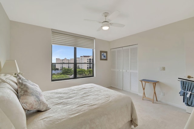 carpeted bedroom featuring ceiling fan and a closet