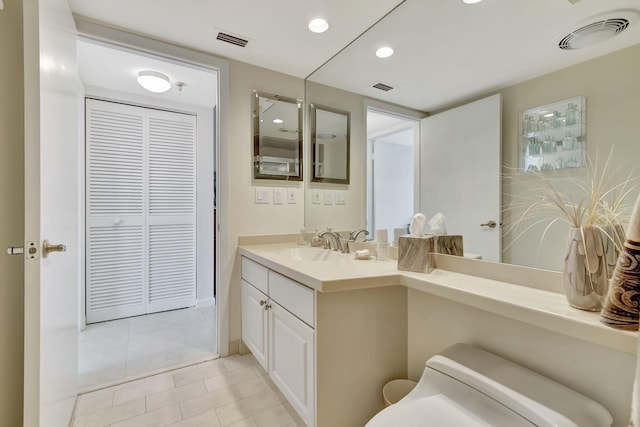 bathroom featuring vanity, tile patterned floors, and toilet