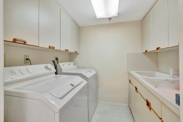 clothes washing area featuring washer and clothes dryer and cabinets