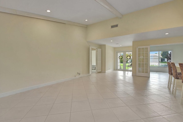 unfurnished room with beamed ceiling, french doors, and light tile patterned floors