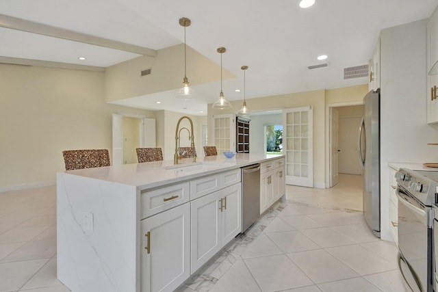 kitchen featuring a center island with sink, appliances with stainless steel finishes, white cabinetry, sink, and decorative light fixtures